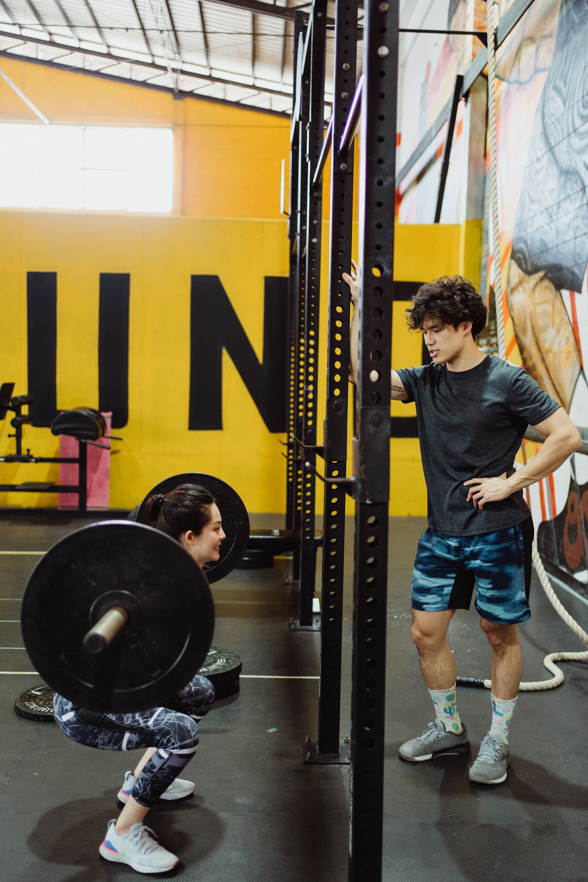 Spor salonunda halterle çalışan bir kişi