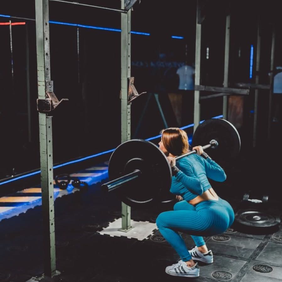 Salonda halterle squat yapan kadın