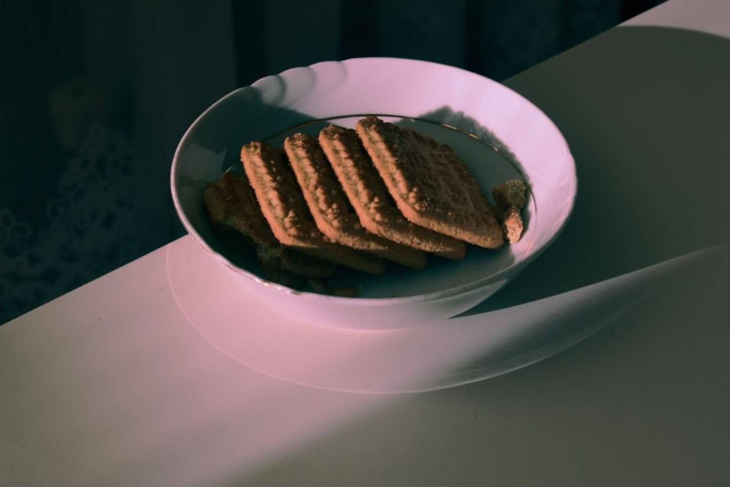 Loş ışıkta bir tabakta duran bisküviler