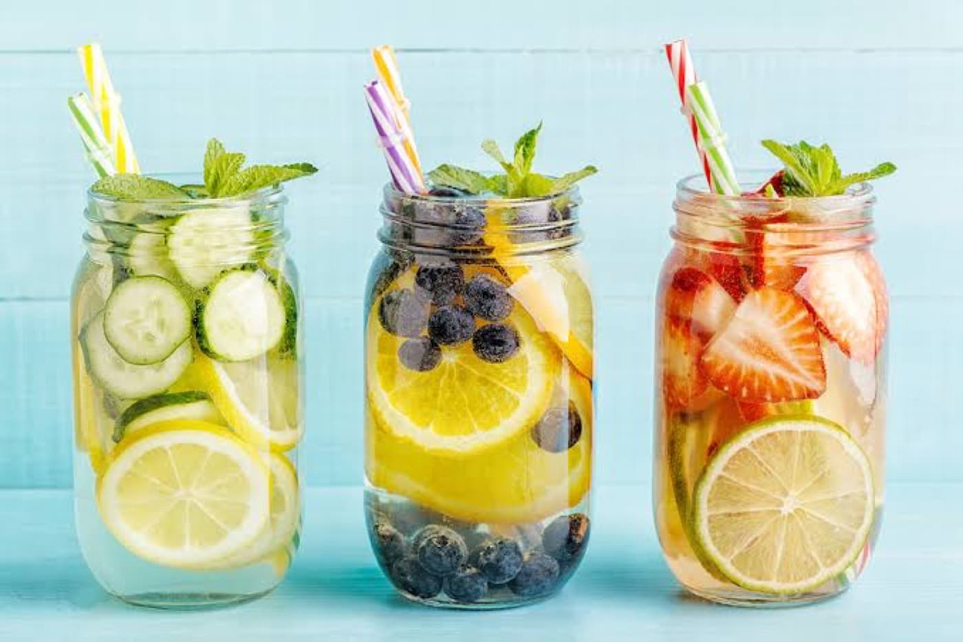 Kavanozlarda salatalık, limon, yaban mersini ve çilekle hazırlanmış meyveli aromalı sular