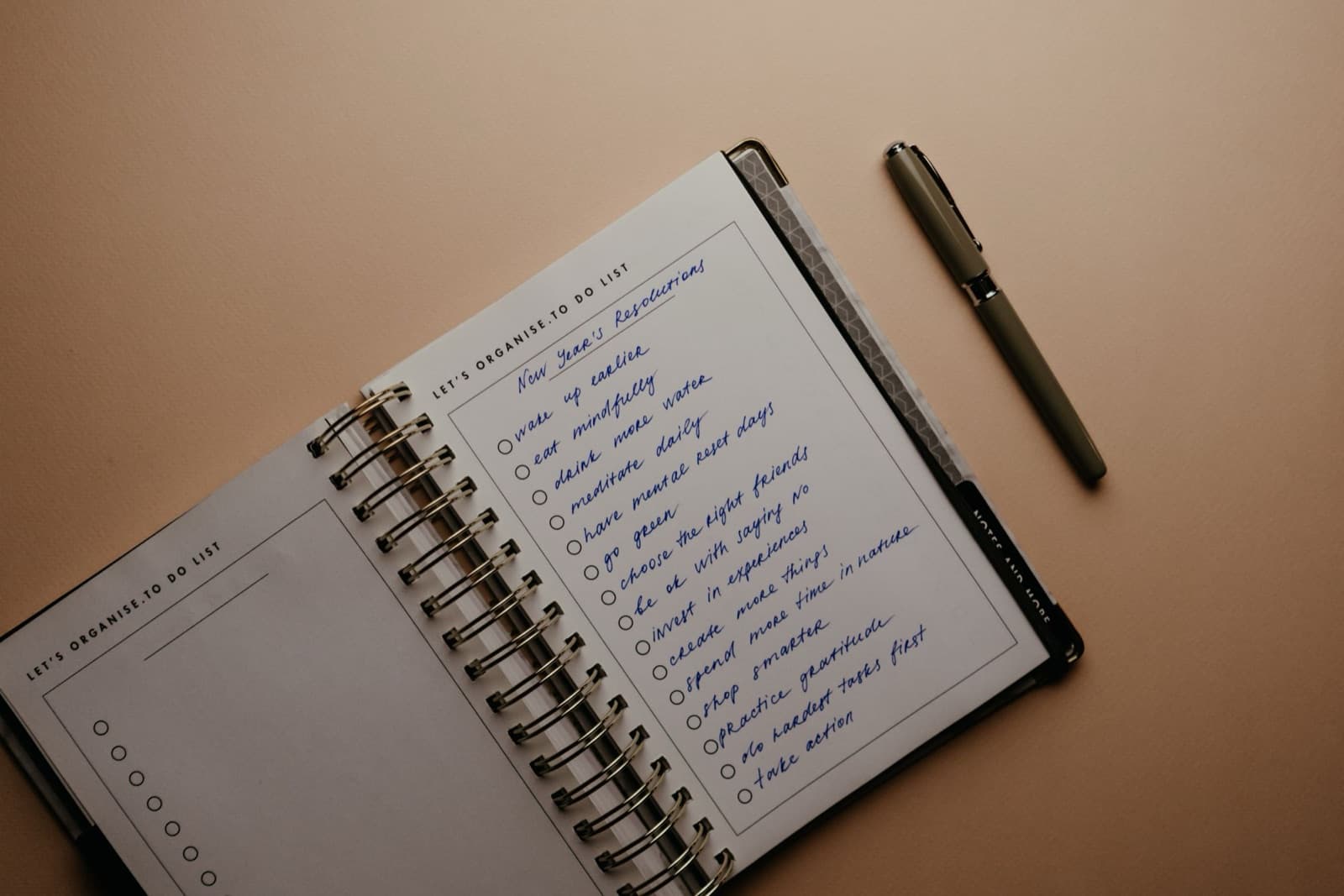 Elle yazılmış kişisel bir hedef listesi içeren defter ve yanında duran bir kalem