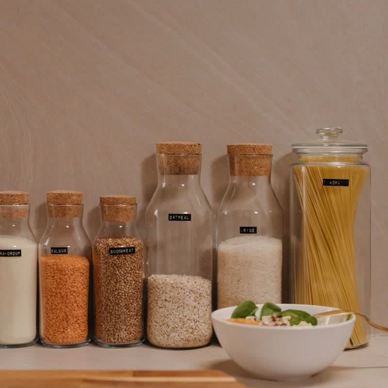 Mutfak rafında cam kavanozlarda mercimek, pirinç, un ve makarna