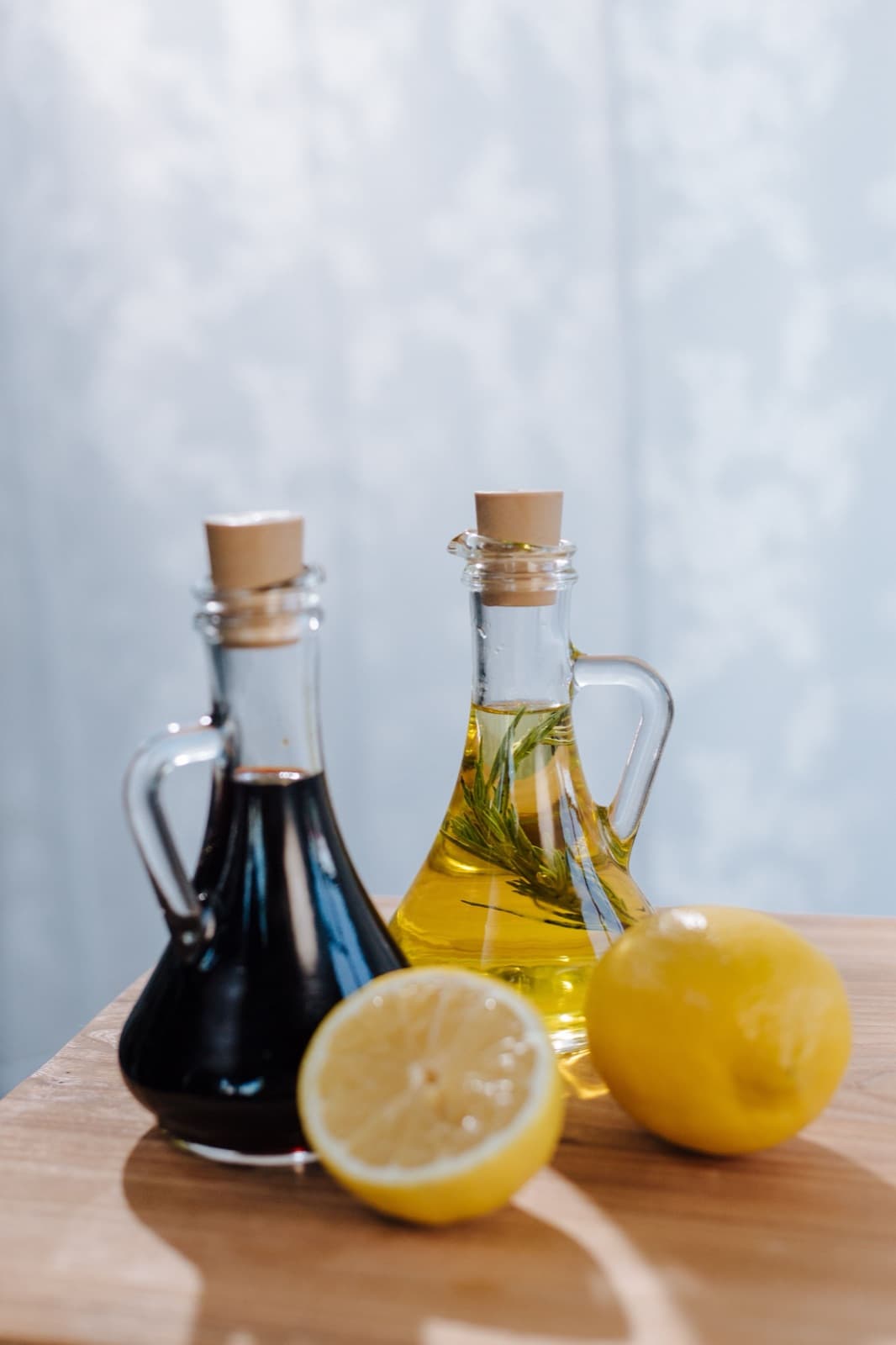 Koyu sirke ve zeytinyağı şişeleri, yanlarında limon