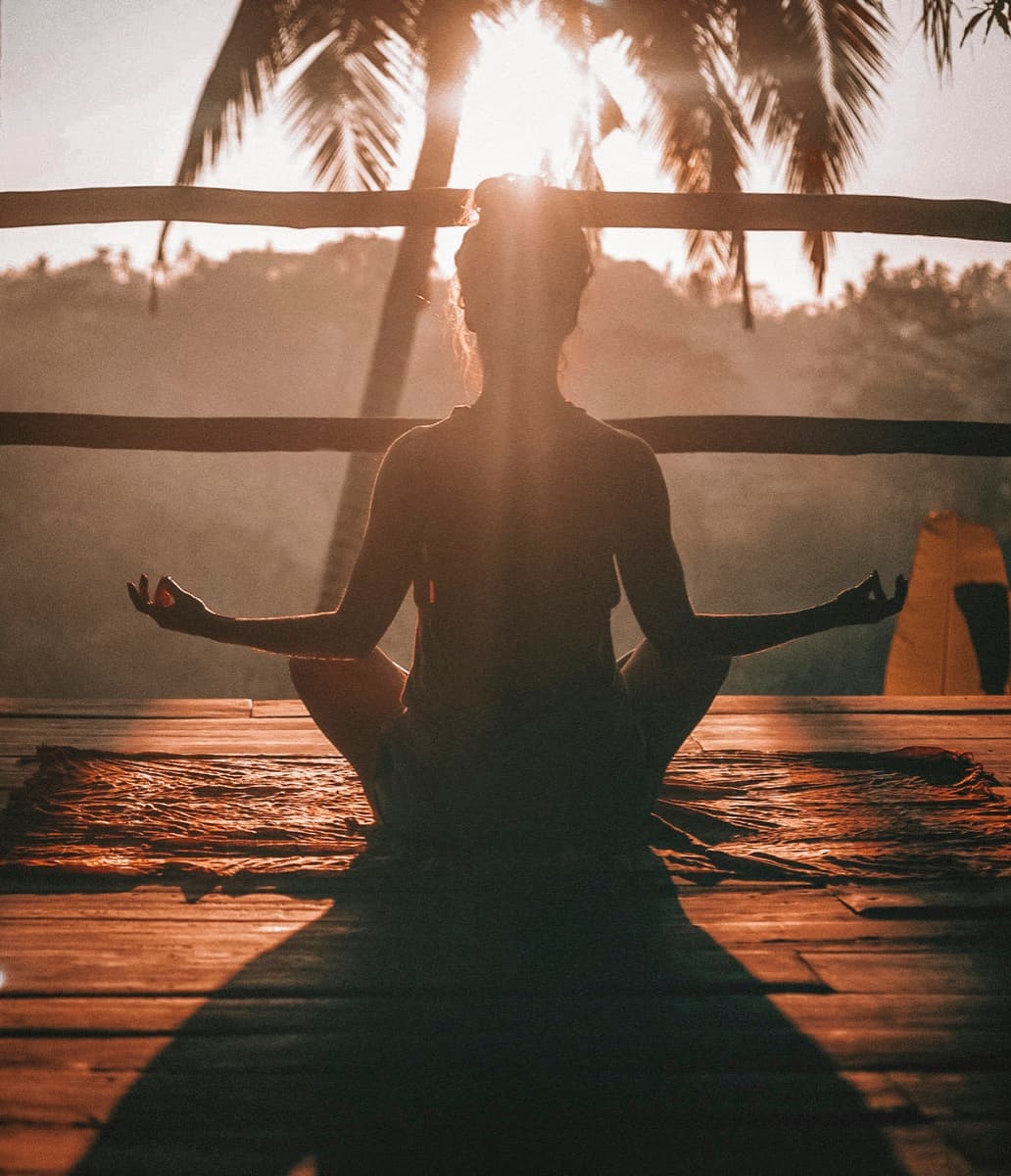 Gün batımında meditasyon yapan siluet — yeme davranışında zihinsel farkındalık