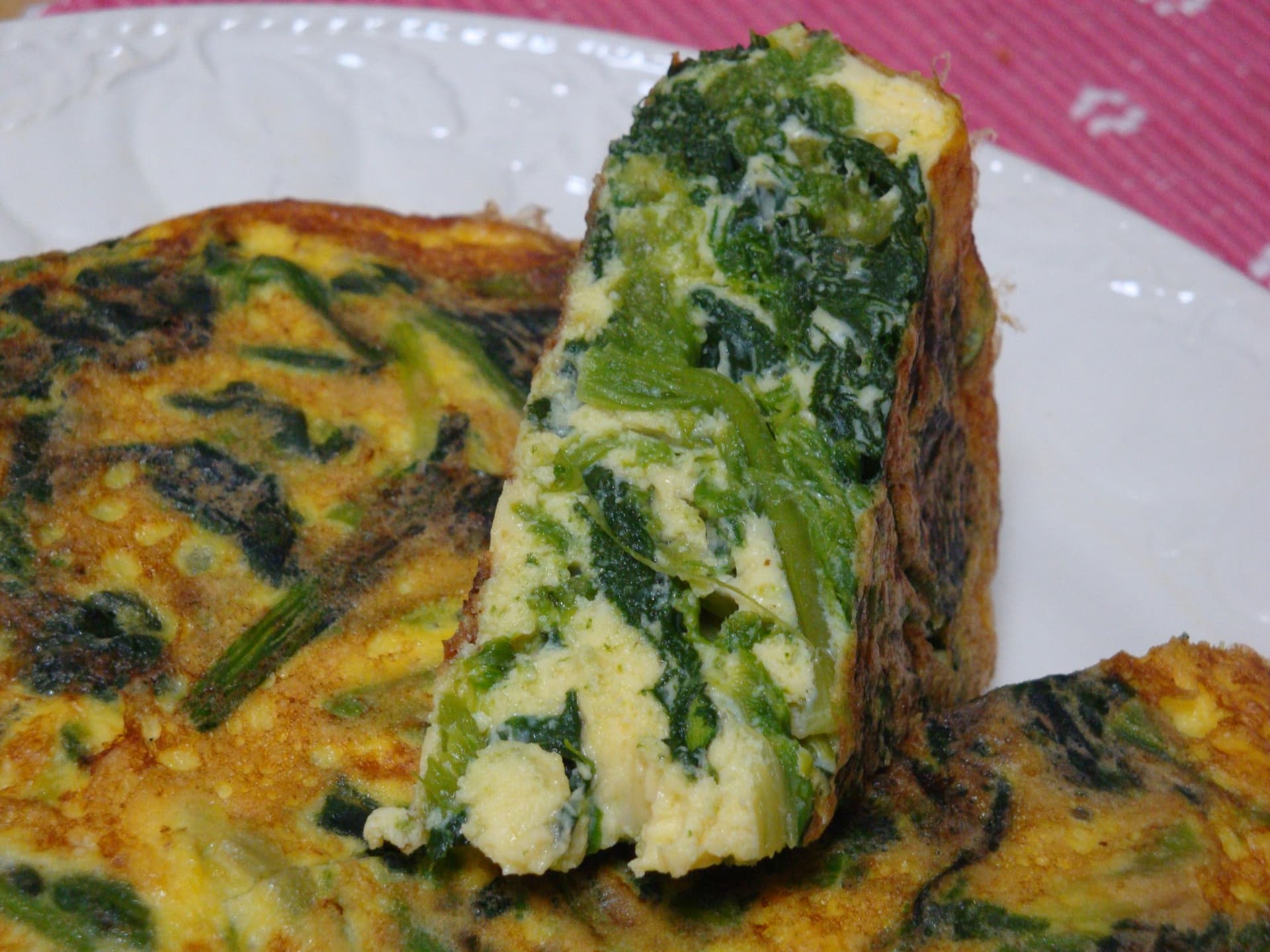 Tabakta ıspanaklı omlet dilimi, kesitinde yeşil ıspanak yaprakları görünüyor