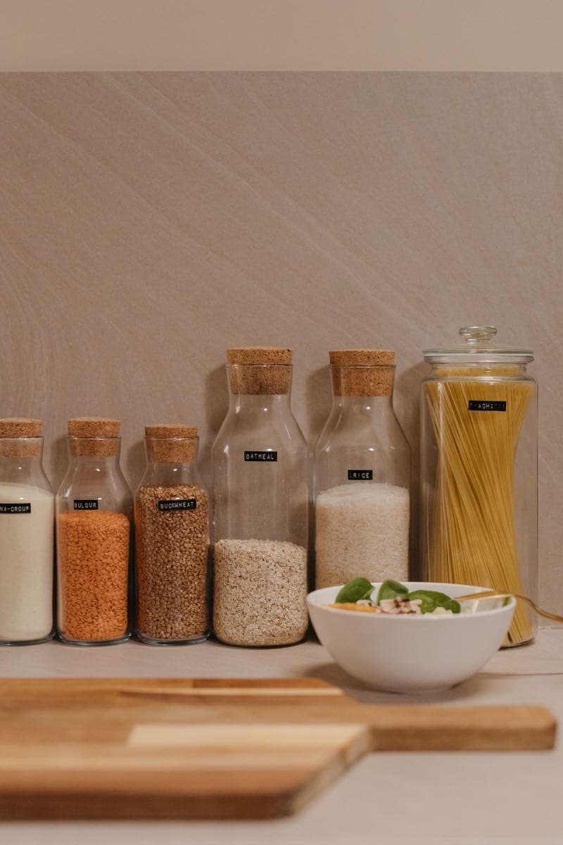 Mutfak rafında cam kavanozlarda mercimek, pirinç, un ve makarna