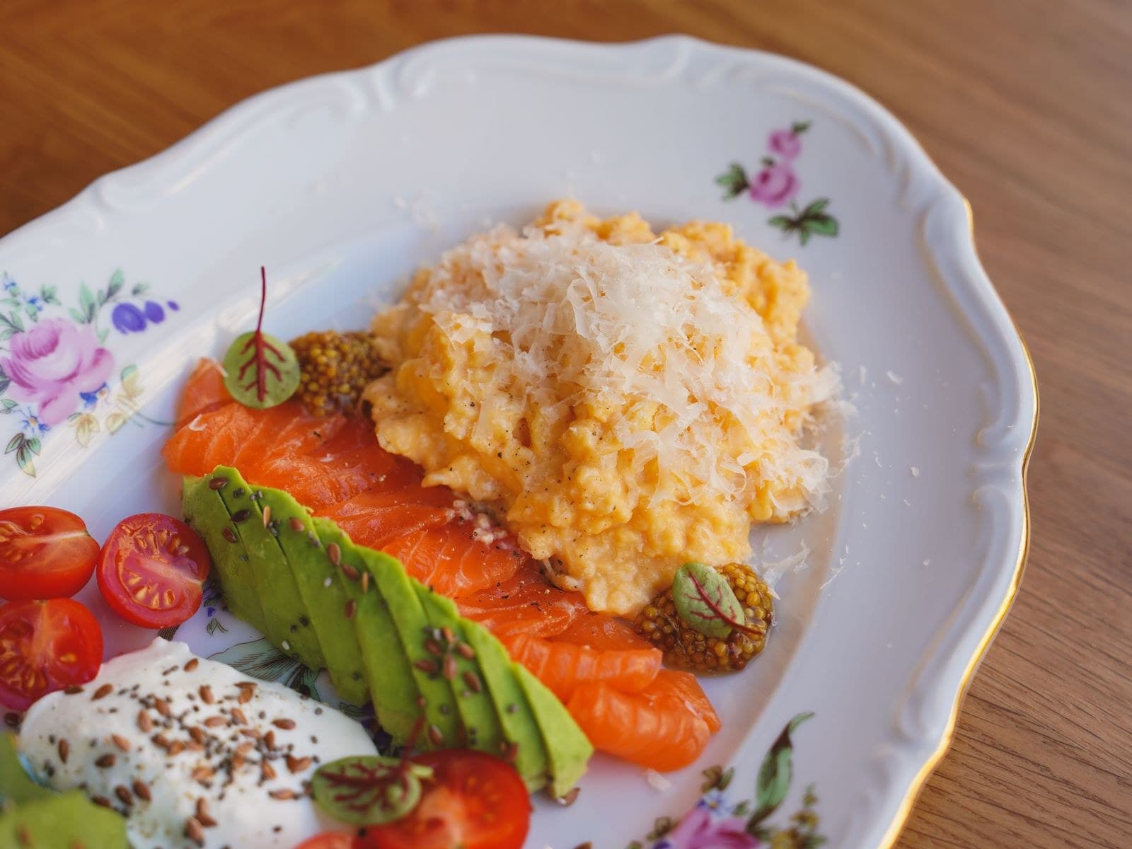 Porselen tabakta çırpılmış yumurta, rendelenmiş peynir, füme somon, avokado ve yoğurt