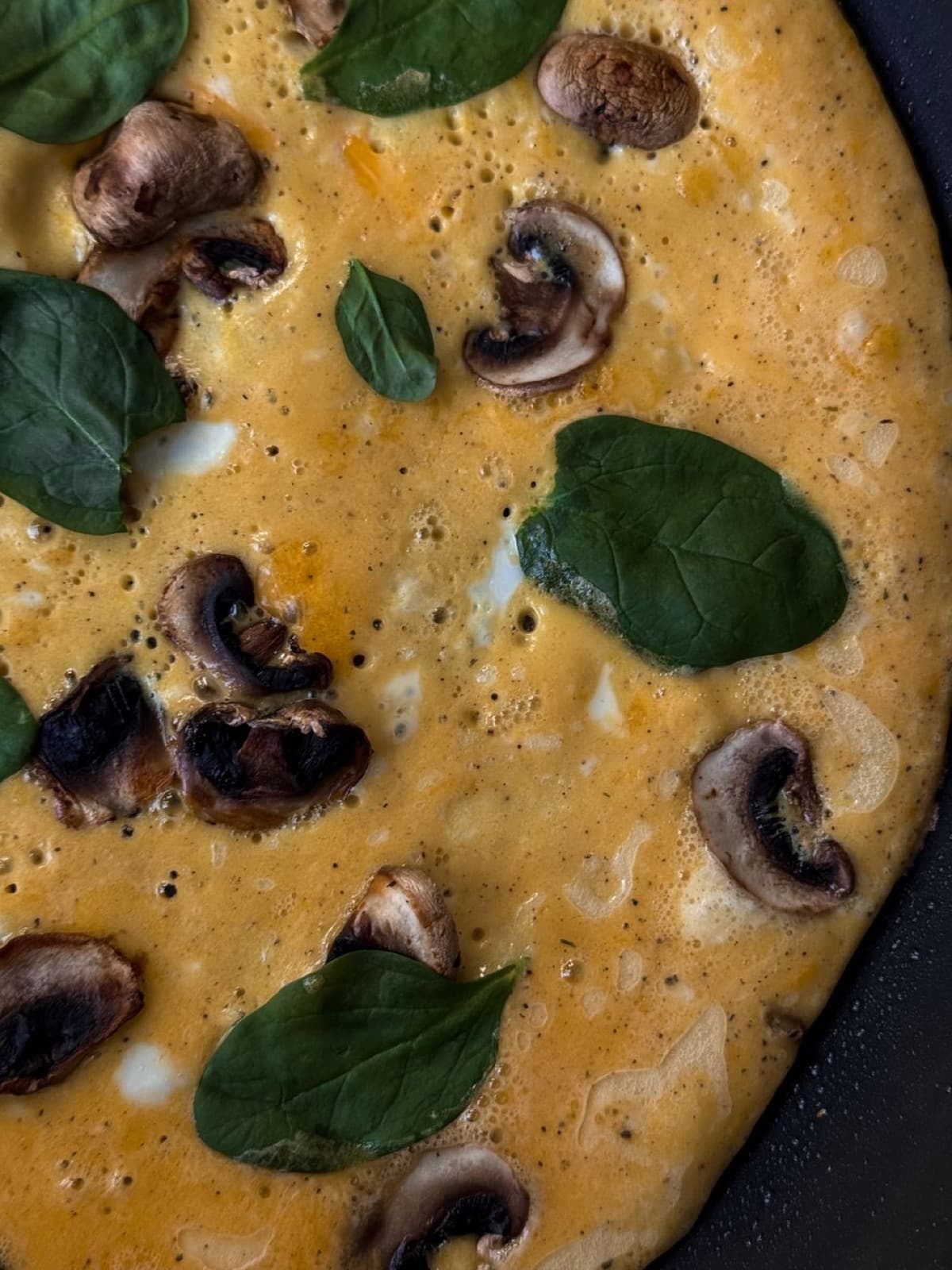 Tavada mantarlı omlet, üzerinde taze yapraklar
