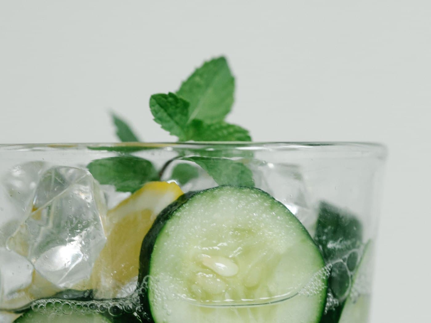 Buzlu bardakta salatalık dilimleri, limon ve nane yapraklarıyla aromalandırılmış su
